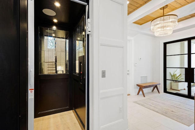 interior space featuring beamed ceiling, visible vents, a notable chandelier, elevator, and wooden ceiling