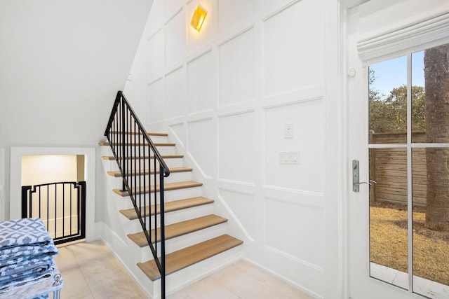 staircase with tile patterned flooring and a decorative wall