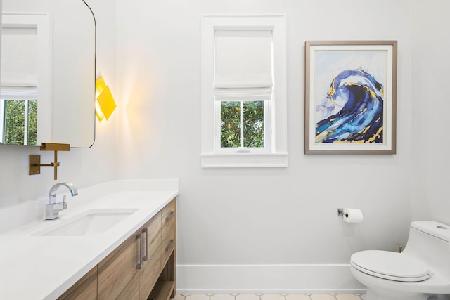 half bathroom with toilet, vanity, and baseboards