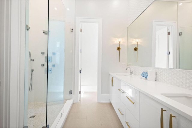 bathroom featuring a sink, backsplash, a stall shower, and double vanity