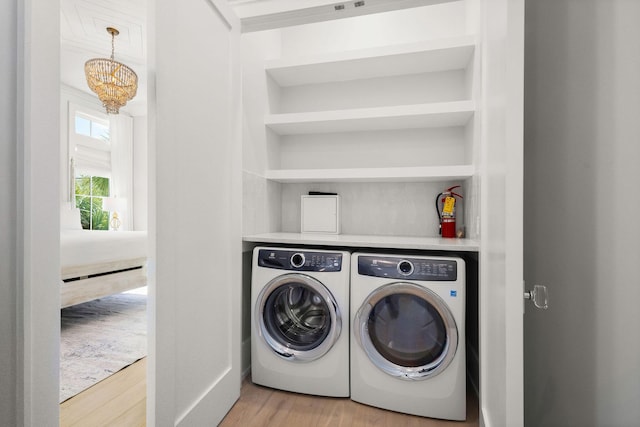 laundry area with washing machine and clothes dryer, laundry area, and light wood-style floors