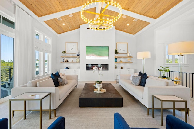 living area featuring a glass covered fireplace, beamed ceiling, a wealth of natural light, and wooden ceiling