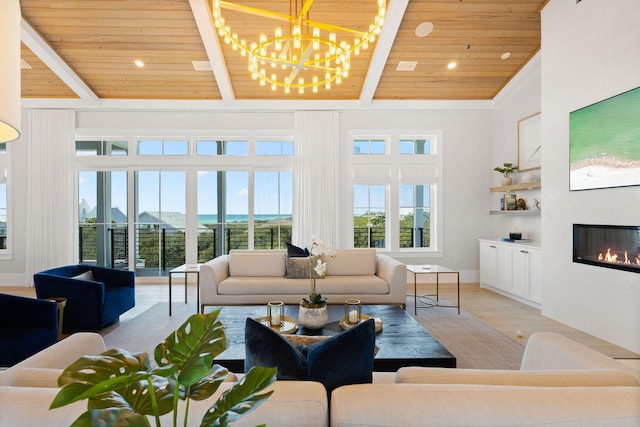 living room featuring beamed ceiling, high vaulted ceiling, wood finished floors, a glass covered fireplace, and wood ceiling