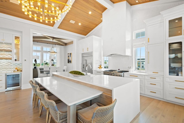 kitchen with stove, wine cooler, wooden ceiling, and stainless steel built in refrigerator