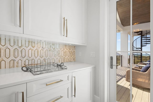 bar featuring stovetop, backsplash, and wood finished floors