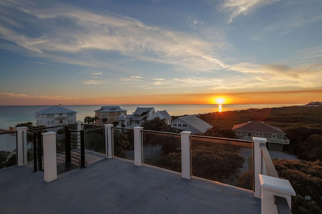 patio terrace at dusk with a balcony and a water view