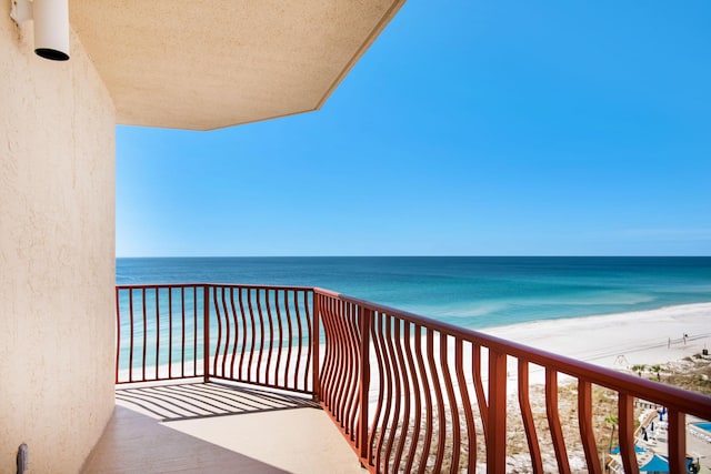 balcony with a water view and a beach view