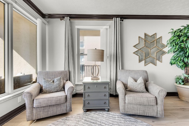 living area featuring ornamental molding, a textured ceiling, and wood finished floors