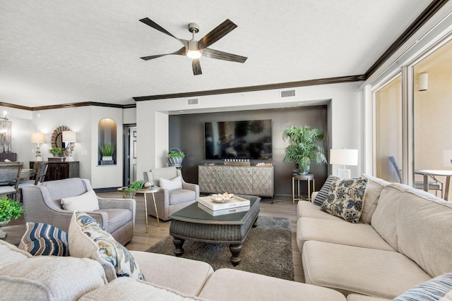 living area with visible vents, a textured ceiling, and wood finished floors