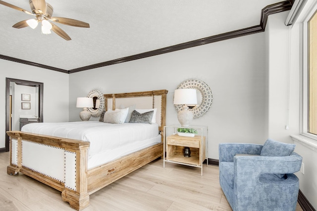 bedroom featuring baseboards, crown molding, light wood-style flooring, and a textured ceiling