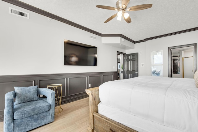 bedroom with ornamental molding, visible vents, and a textured ceiling