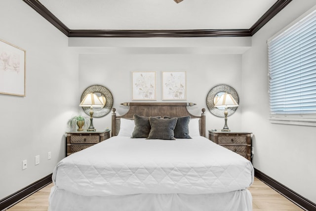 bedroom with multiple windows, crown molding, baseboards, and wood finished floors