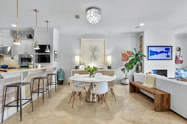 dining room featuring a fireplace, recessed lighting, visible vents, ornamental molding, and baseboards