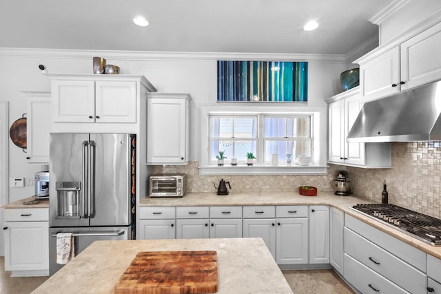 kitchen with white cabinets, under cabinet range hood, ornamental molding, and stainless steel appliances