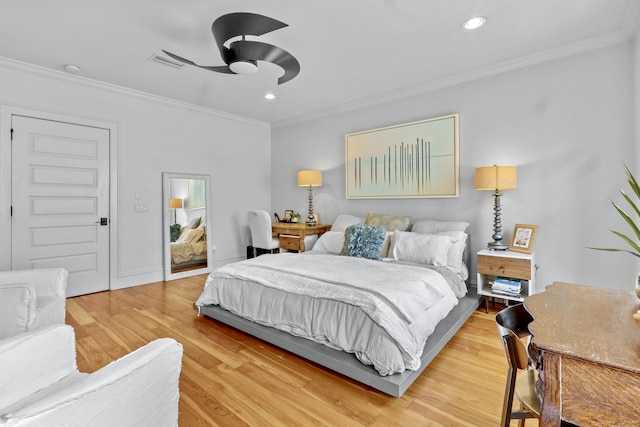 bedroom featuring visible vents, crown molding, and light wood finished floors