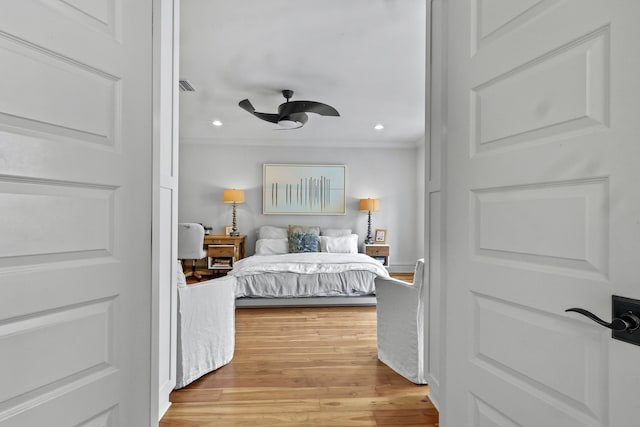 bedroom featuring light wood-style floors, recessed lighting, visible vents, and crown molding