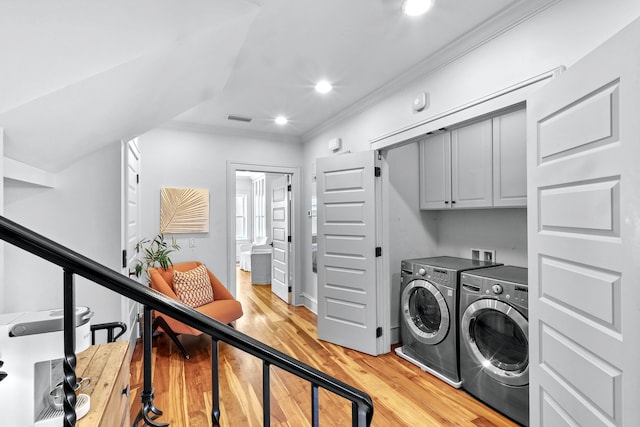 laundry area with cabinet space, visible vents, light wood-style flooring, ornamental molding, and independent washer and dryer