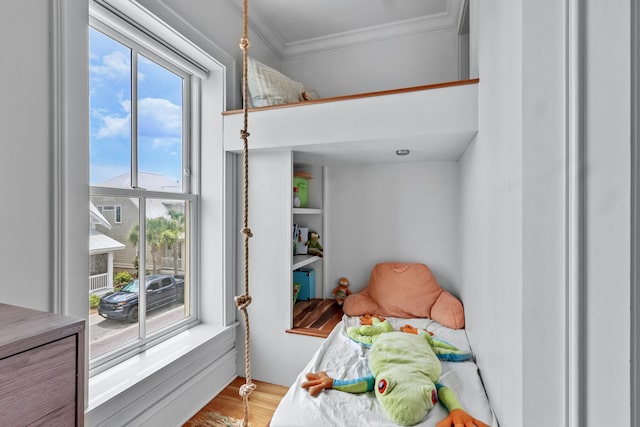 bedroom with crown molding and wood finished floors