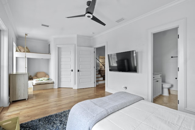 bedroom with connected bathroom, light wood-type flooring, visible vents, and crown molding