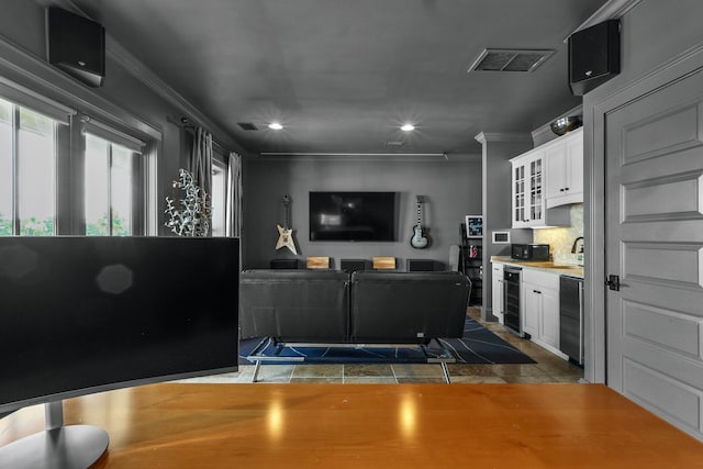 living area with wine cooler, recessed lighting, visible vents, and crown molding