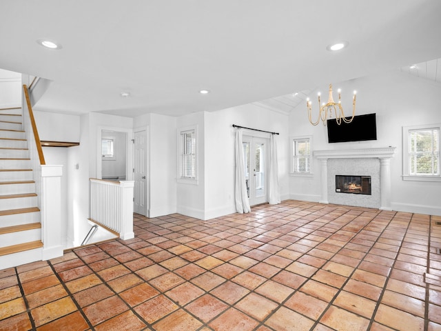 unfurnished living room featuring stairs, a glass covered fireplace, vaulted ceiling, and recessed lighting