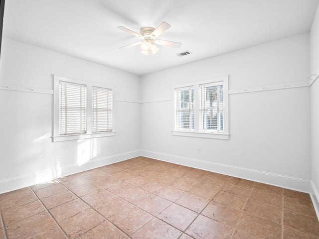 unfurnished room featuring ceiling fan, visible vents, and baseboards