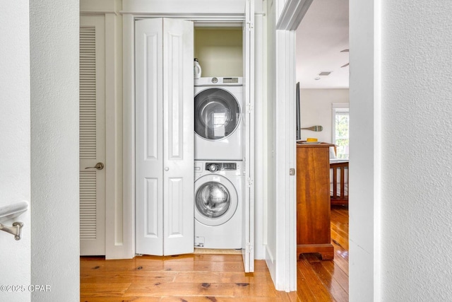 115 Cottage Ct, Panama City Beach, FL 32413 - washroom featuring stacked washer / drying machine and light wood-type flooring