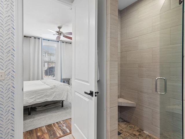 bathroom with wood finished floors, a stall shower, ensuite bath, and a ceiling fan