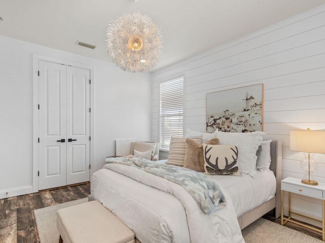 bedroom featuring a chandelier, a closet, dark wood finished floors, and visible vents