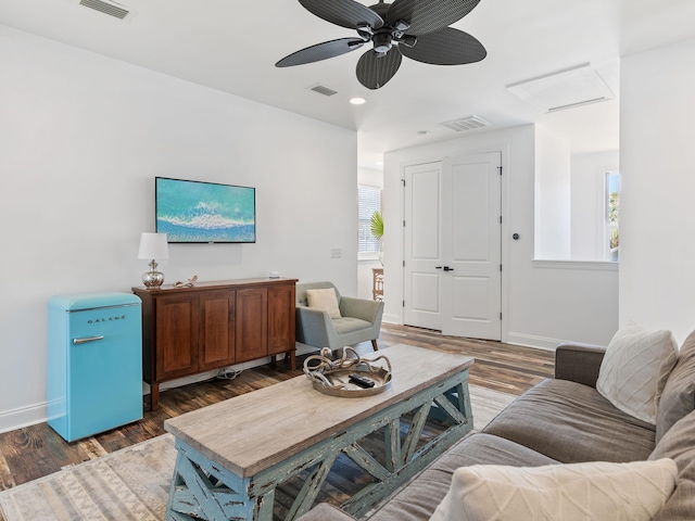 living area featuring dark wood-style floors, visible vents, and baseboards