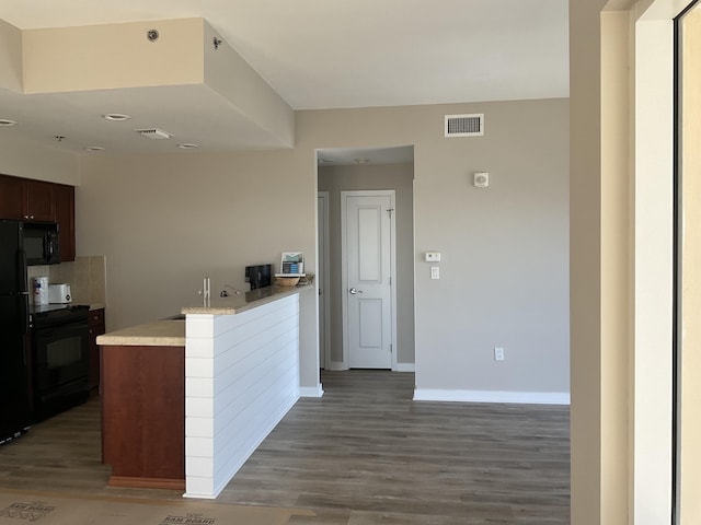 kitchen with sink, dark hardwood / wood-style floors, and black appliances