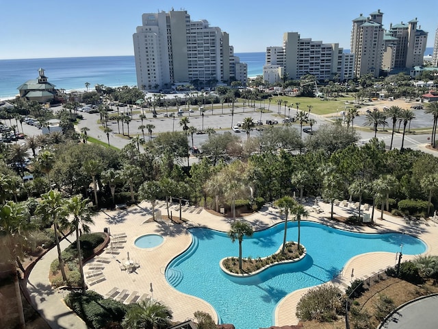 view of swimming pool featuring a water view and a patio