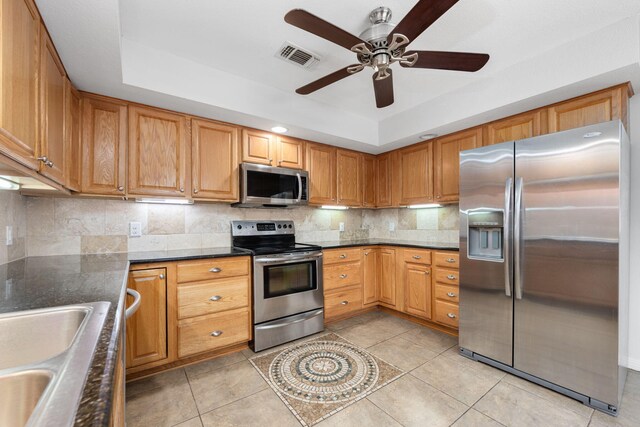 117 Hibiscus Ave, Gulf Breeze, FL 32561 - kitchen with stainless steel appliances, a raised ceiling, visible vents, and backsplash
