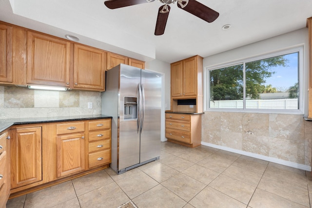 117 Hibiscus Ave, Gulf Breeze, FL 32561 - kitchen featuring brown cabinetry, dark stone counters, stainless steel fridge, and backsplash