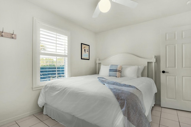 bedroom featuring light tile patterned floors, baseboards, and a ceiling fan