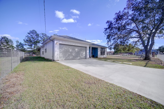 exterior space with an attached garage, driveway, fence, and a front yard