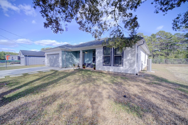 ranch-style house featuring an attached garage, driveway, fence, and a front lawn