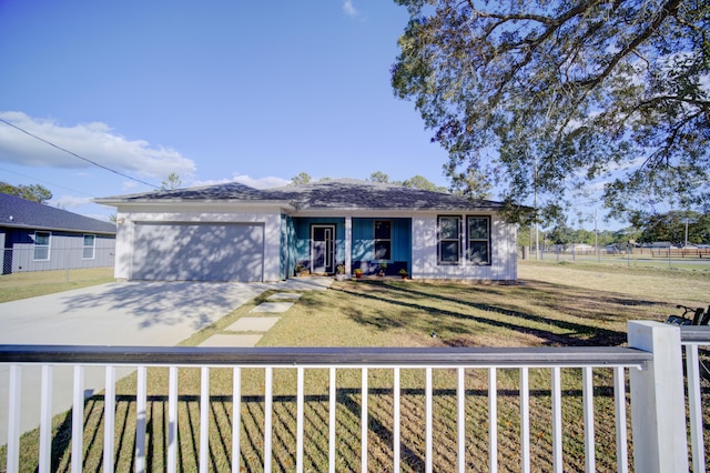 view of front of property featuring concrete driveway, a front lawn, an attached garage, and fence