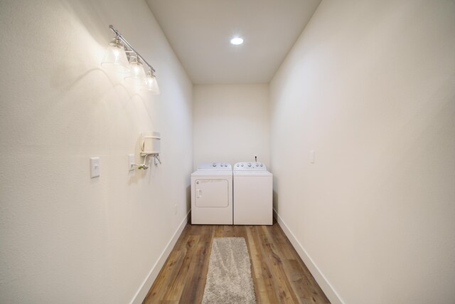 laundry room with baseboards, laundry area, wood finished floors, and washer and dryer