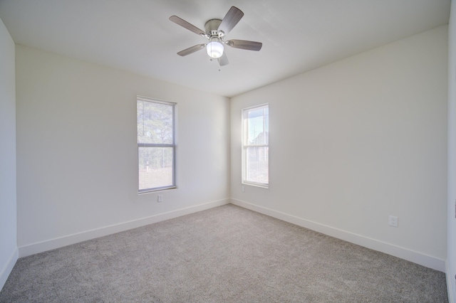 unfurnished room with carpet floors, baseboards, and a ceiling fan