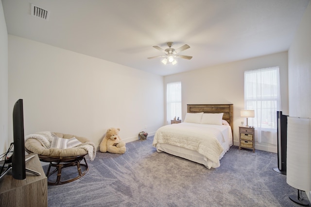 carpeted bedroom with a ceiling fan, visible vents, and baseboards