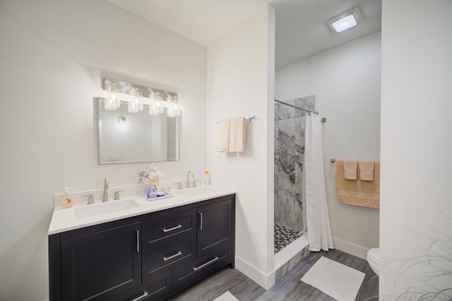 bathroom with a sink, a shower stall, toilet, and wood finished floors