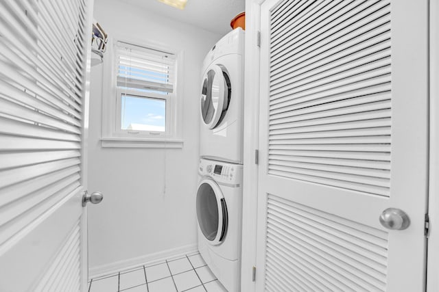 laundry room with stacked washer and clothes dryer and light tile patterned floors