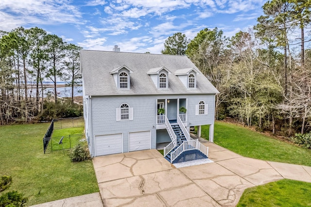 view of front of property featuring a front yard, concrete driveway, roof with shingles, and an attached garage