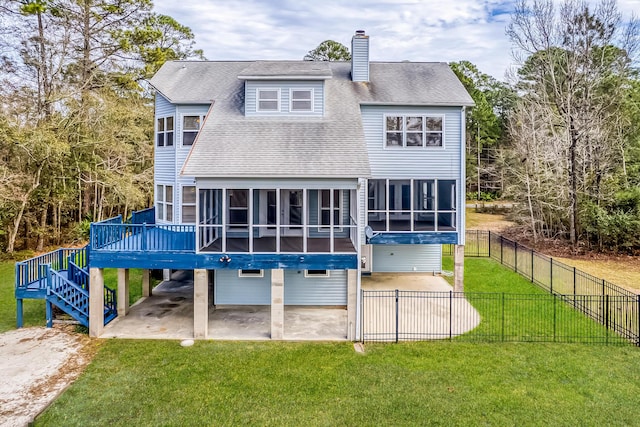 rear view of house featuring a yard, a shingled roof, a sunroom, a patio area, and a fenced backyard