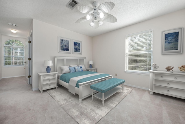 bedroom with light carpet, multiple windows, and visible vents