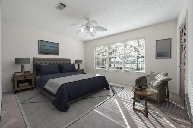 bedroom with a textured ceiling, a closet, carpet, and visible vents