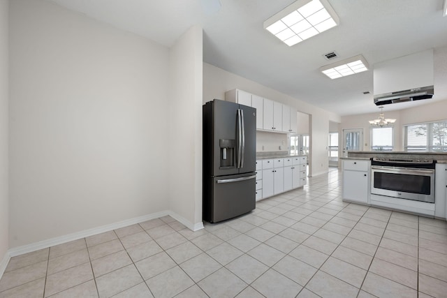 kitchen featuring light tile patterned floors, refrigerator with ice dispenser, electric stove, an inviting chandelier, and white cabinetry