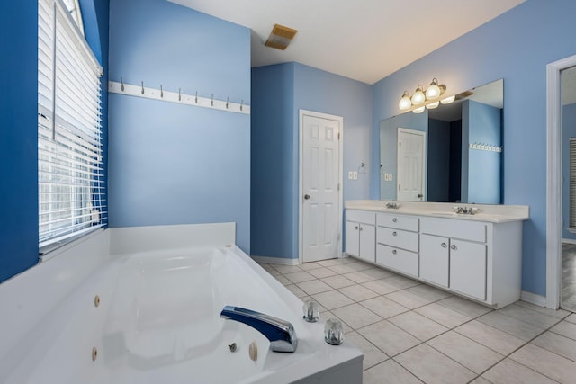 bathroom featuring a sink, a tub with jets, and tile patterned floors