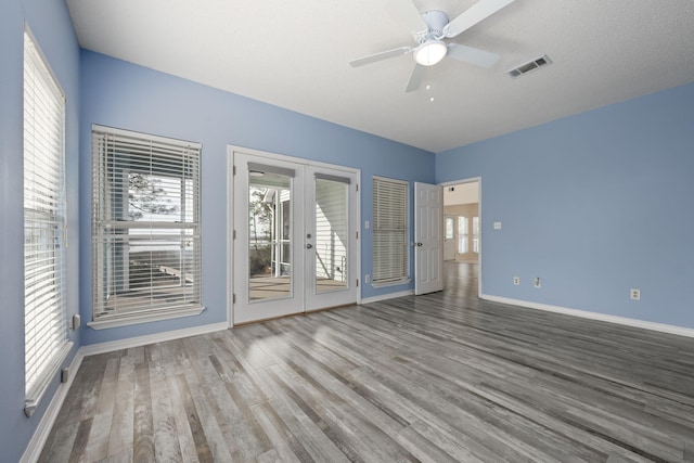 spare room with ceiling fan, wood finished floors, visible vents, baseboards, and french doors